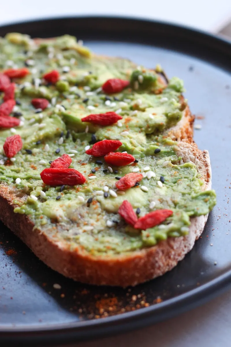 Avocado toast garni d'amandes, noisettes et baies de goji